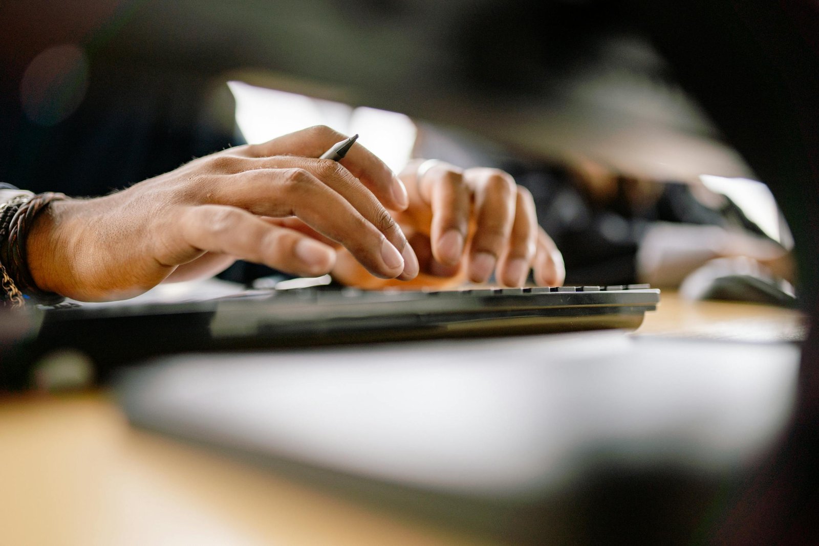 A detailed view of a person typing on a keyboard, emphasizing productivity and office work.
